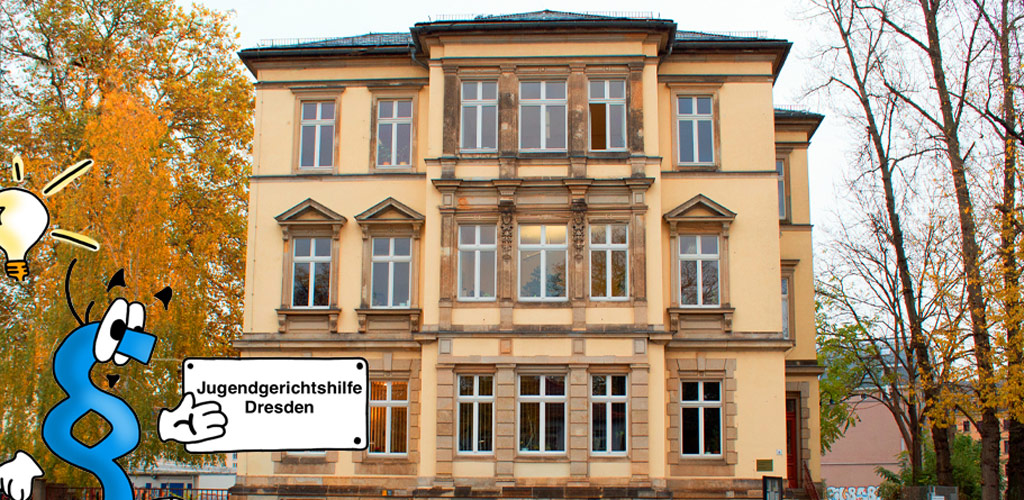 Ein Foto ist dargestellt. Auf dem Foto ist das Gebäude auf der Königsbrücker Straße 8, 01099 Dresden dargestellt. Ein blaues Paragraphen-Männchen mit einer Glühbirne über dem Kopf zeigt auf ein Schild mit der Aufschrift "Jugendgerichtshilfe Dresden".